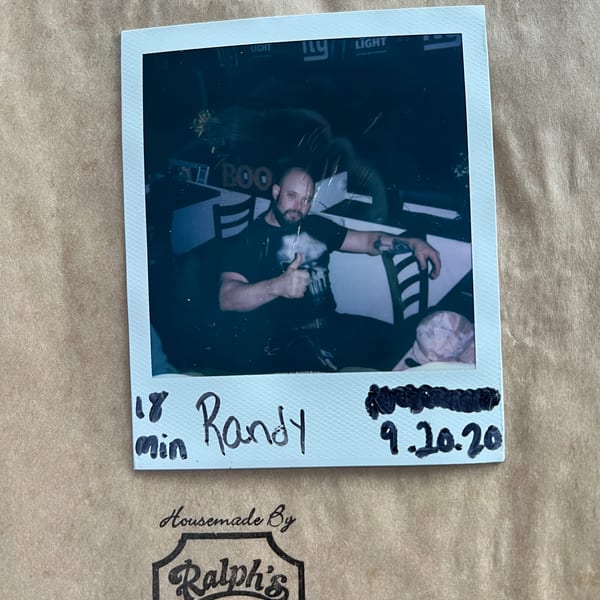 A Polaroid photo of a man giving a thumbs-up, with "Randy 9.10.20" written below, on a Ralph's Sports Bar bag.
