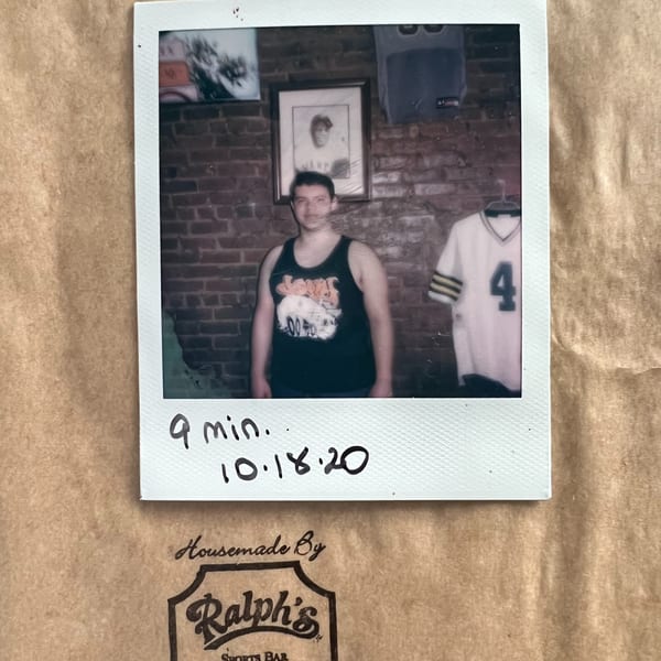 Polaroid photo of a man in a tank top against a brick wall, with a Ralph's Sports Bar logo.